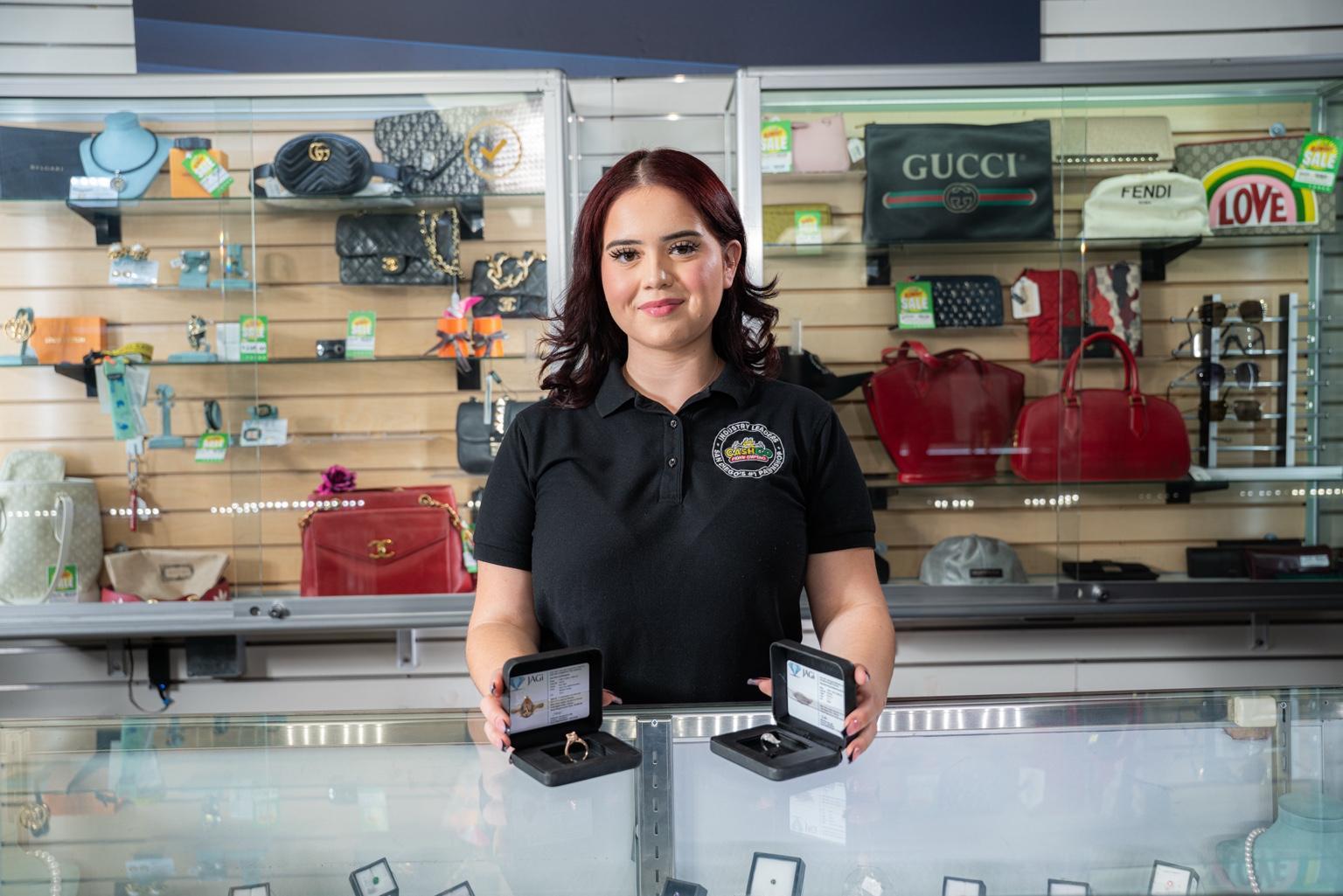 CashCo employee assisting a customer at the jewelry counter